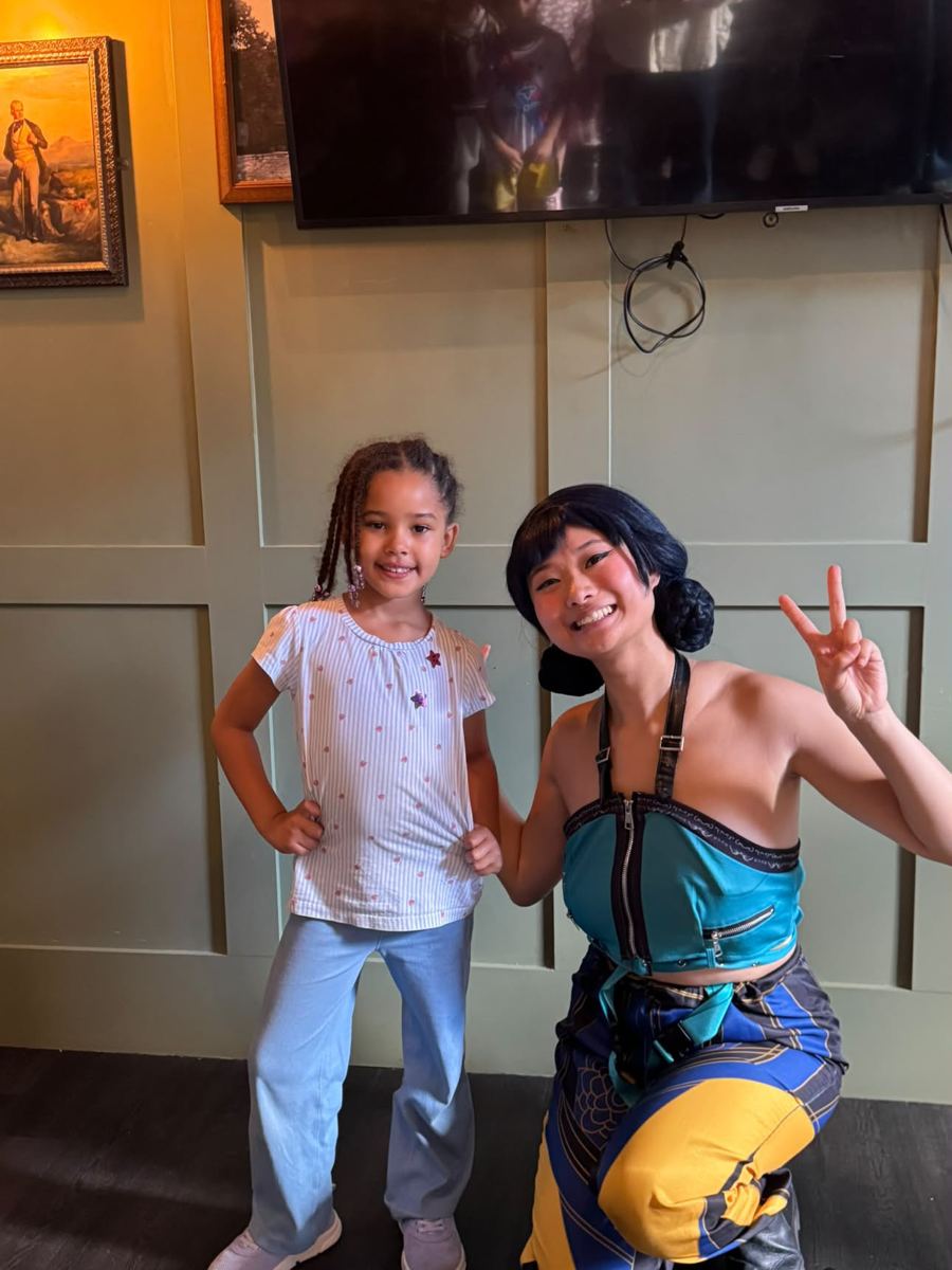 Girl posing hands on hips next to the performer
