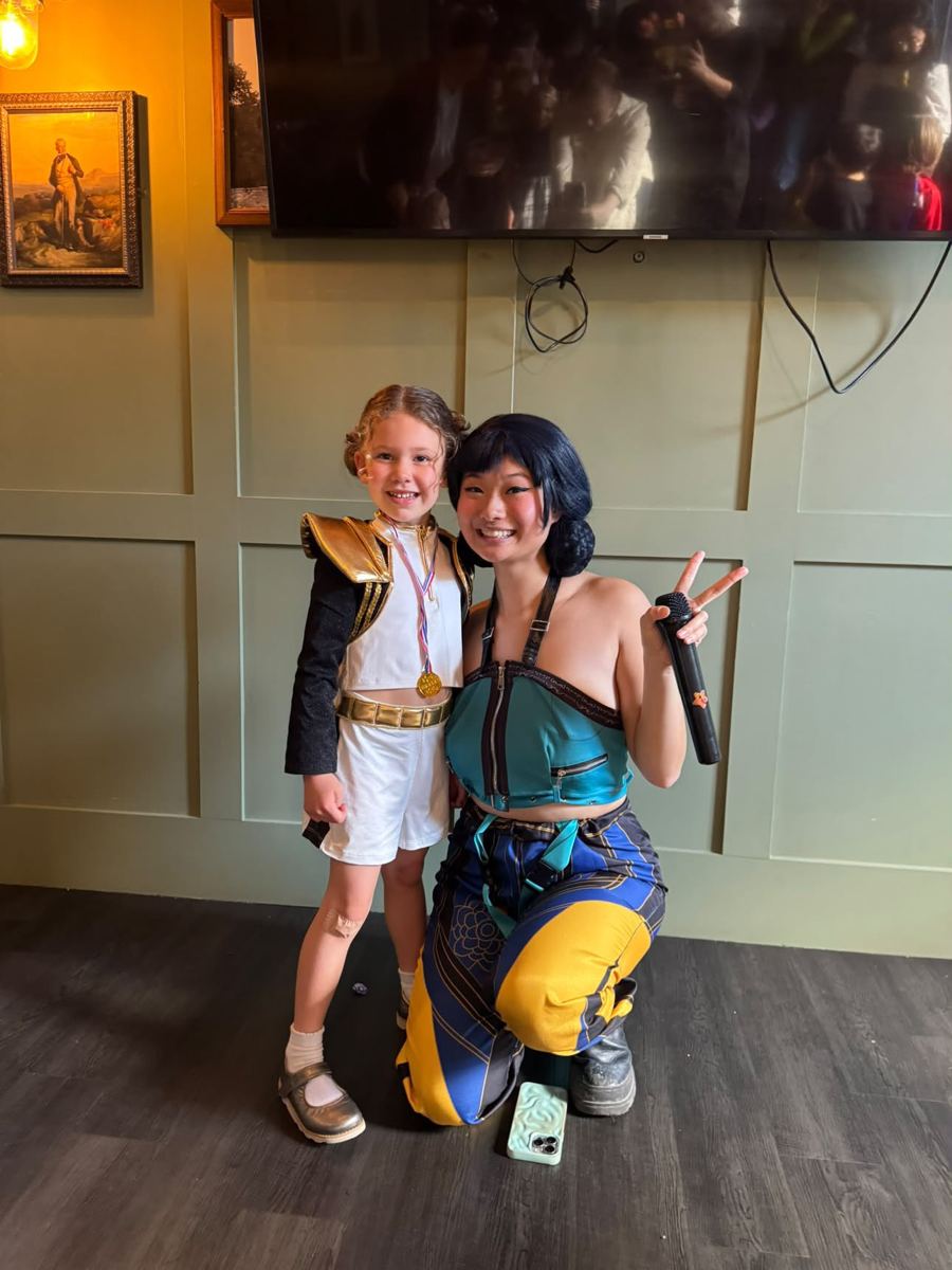 Birthday girl in an idol outfit and medal posing with the performer